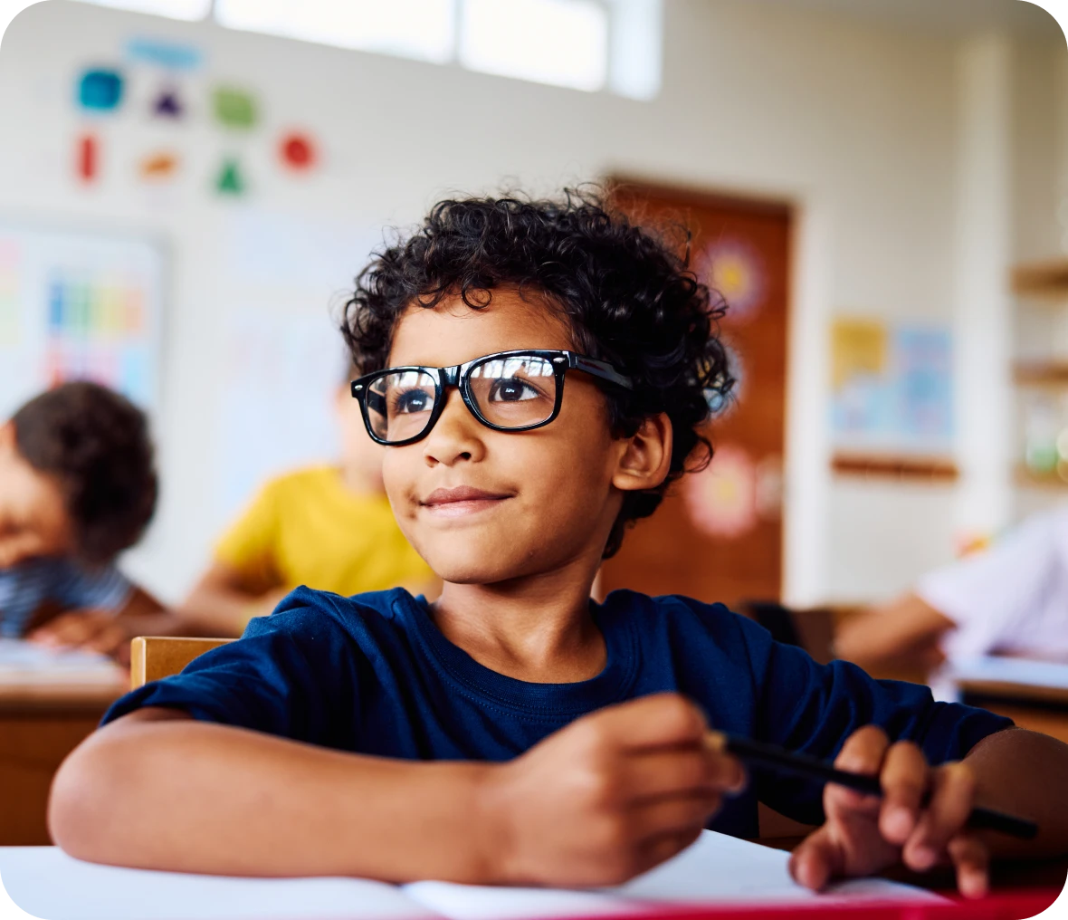 Young student holding pencil in class